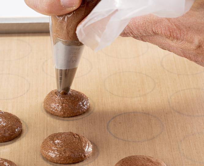 A chef piping macarons