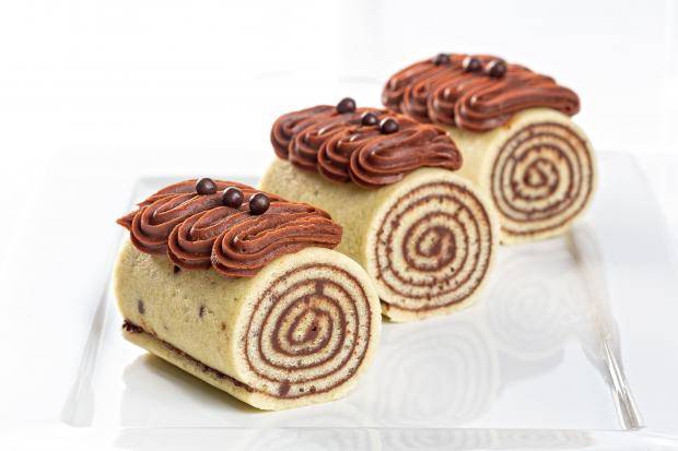 três bolos de rolo lado a lado com ganache firme no topo fazendo zig zag e crispearls amargo mona lisa no topo para decorar