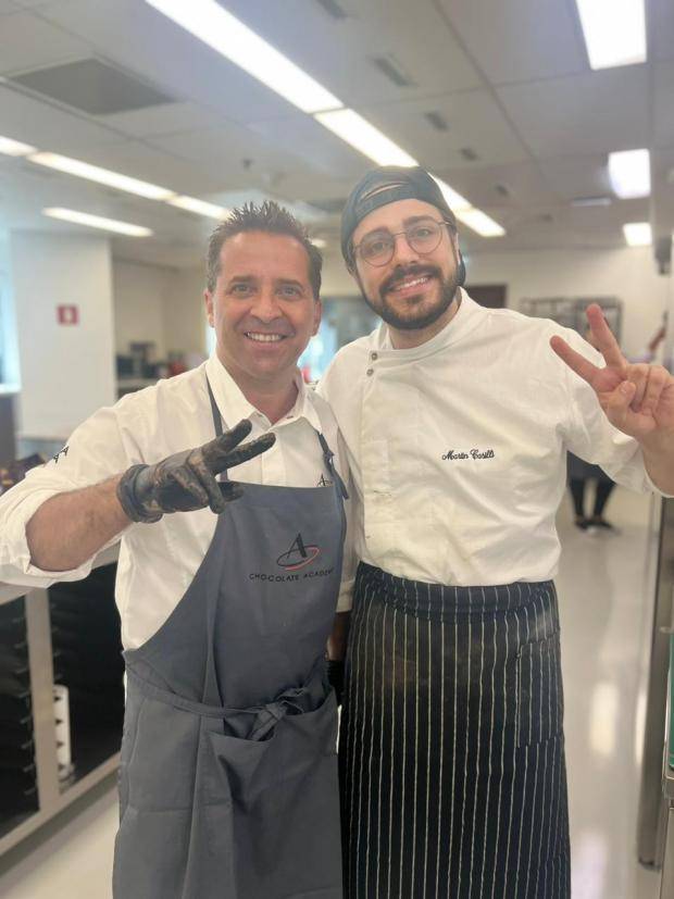 chef bertrand busquet e chef martin abraçados fazendo sinal de paz com os dedos dentro da chocolate academy são paulo