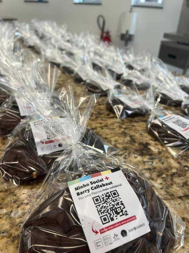 cookies dentro de saquinhos transparente com uma etiqueta indicando o nome da ação e com QR Code para acessar essa matéria