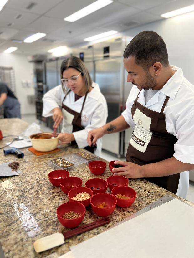 pessoas trabalhando com chocolate em cima do balcão