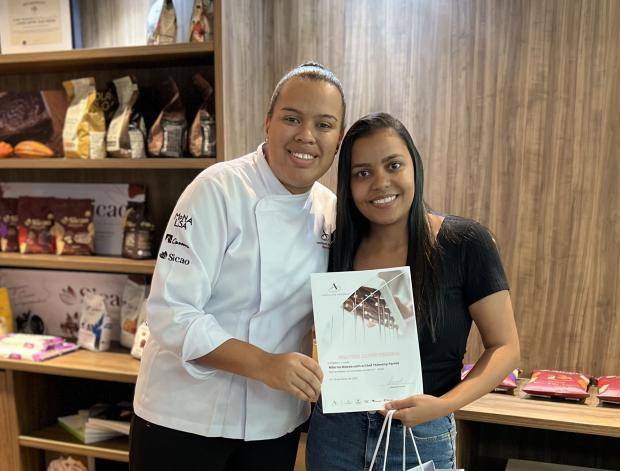 Chef entregando certificado de conclusão de curso para aluna