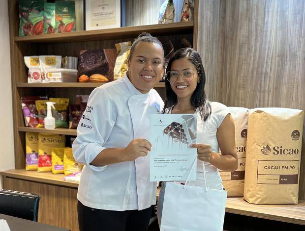 Chef entregando certificado de conclusão de curso para aluna