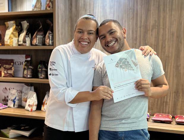 Chef entregando certificado de conclusão de curso para aluna