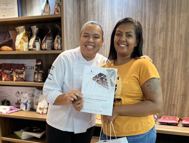Chef entregando certificado de conclusão de curso para aluna