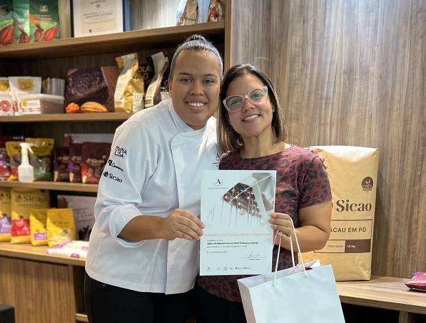 Chef entregando certificado de conclusão de curso para aluna