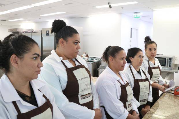 pessoas lado a lado observando a chef dar informações sobre confeitaria