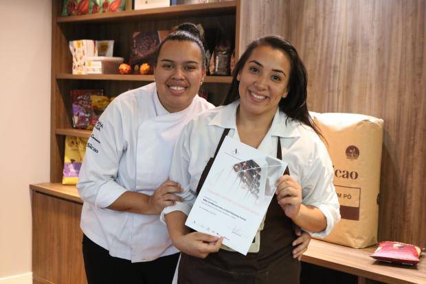 Chef entregando certificado de conclusão de curso para aluna