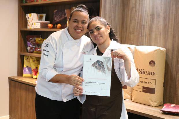 Chef entregando certificado de conclusão de curso para aluna
