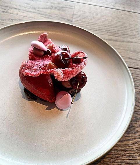 A plated dessert featuring cherries