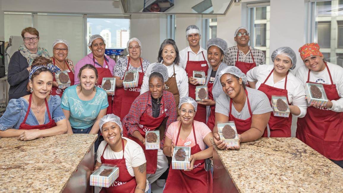 pessoas com o avental da Sicao na Chocolate Academy SP segurando suas criações de Páscoa
