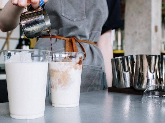 Bir barista süt bazlı içecekler hazırlıyor.
